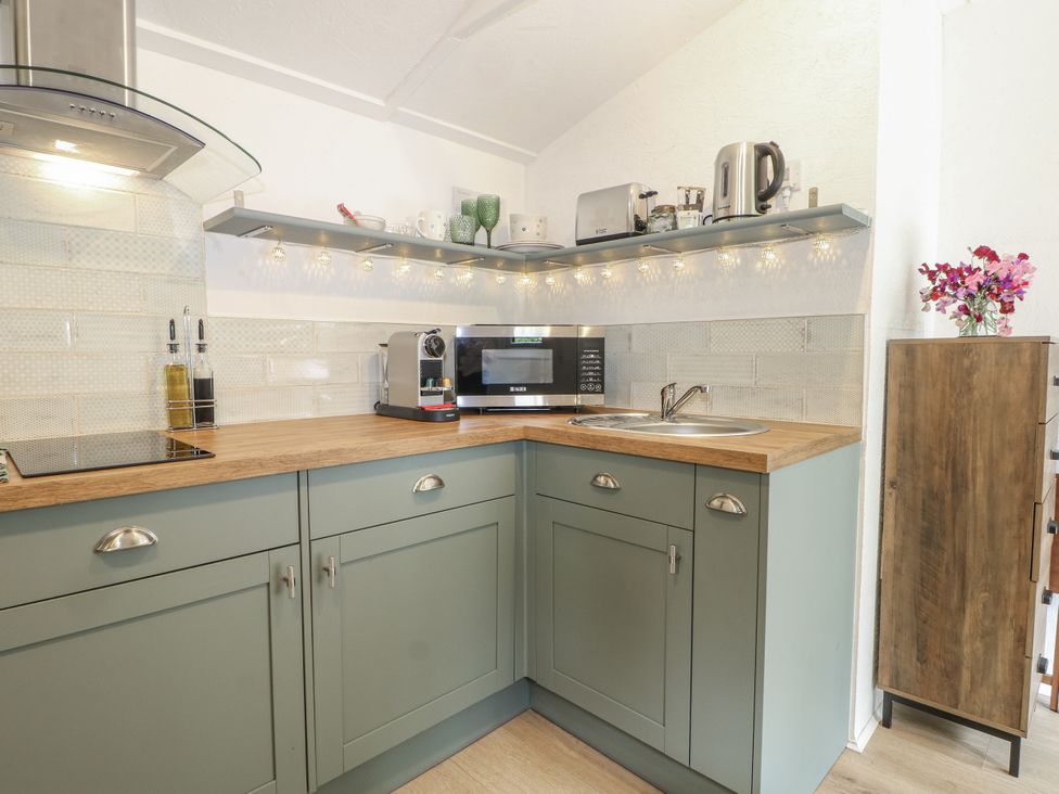 A kitchen with sink, microwave, and coffee machine at Charltons Hollow Cabin, Haywards Heath