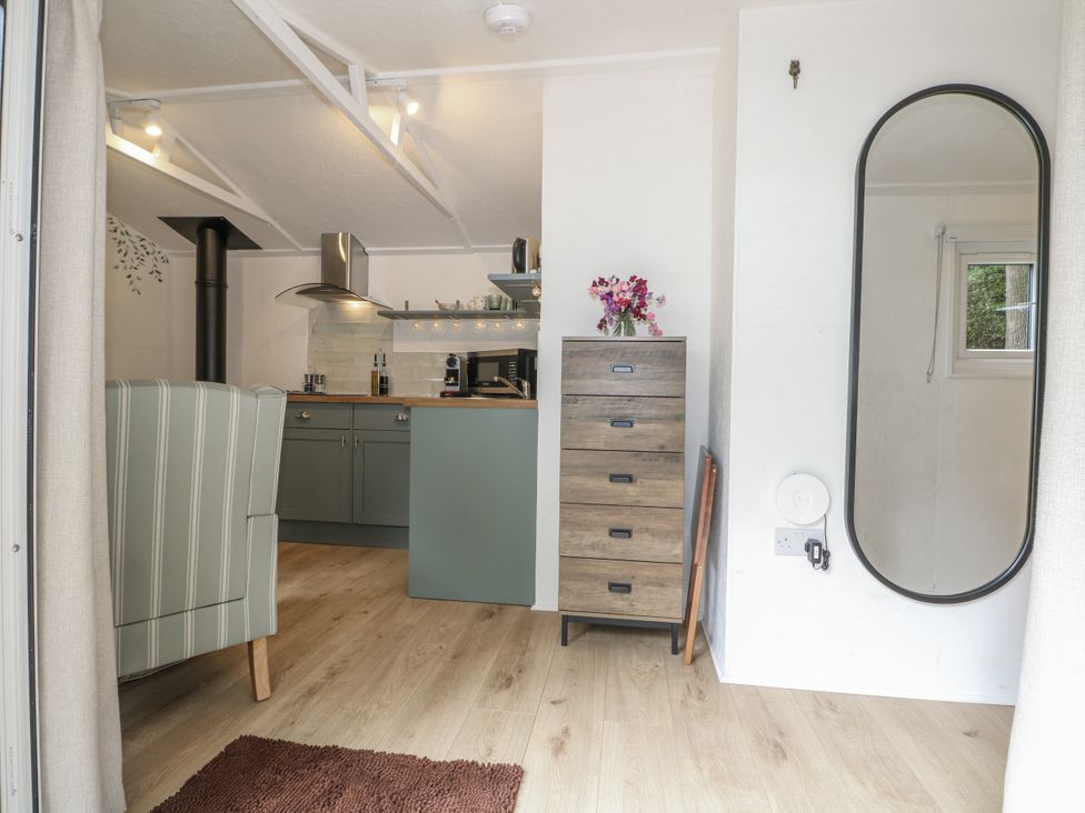 A kitchen area with seating and storage at Charltons Hollow Cabin Haywards Heath