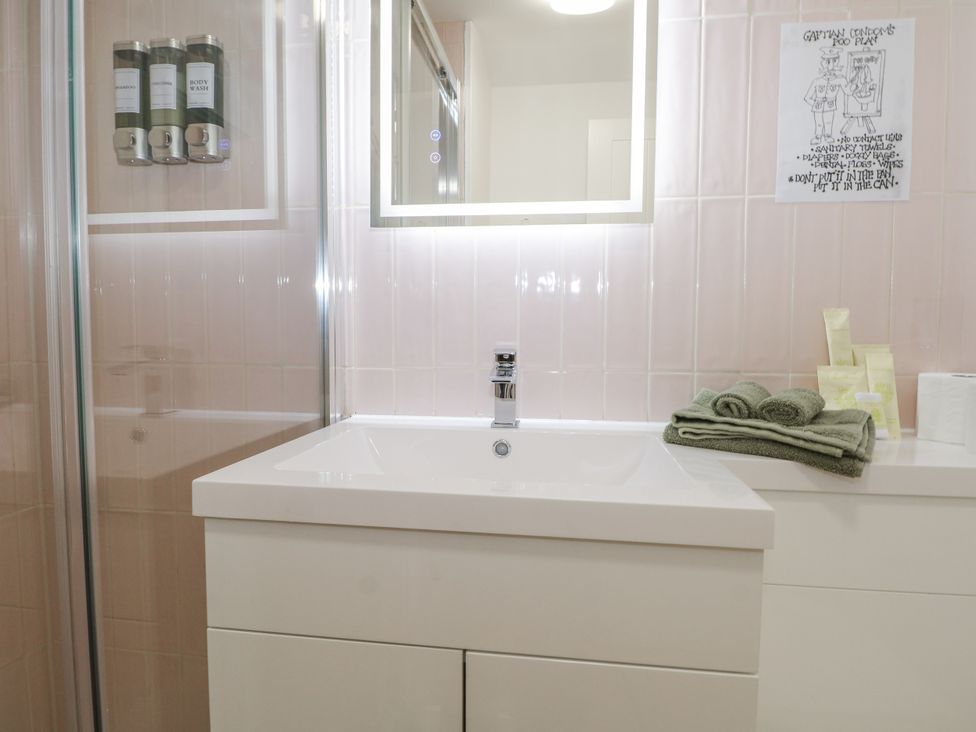 A bathroom with a sink and towels at Charltons Hollow Cabin in Haywards Heath