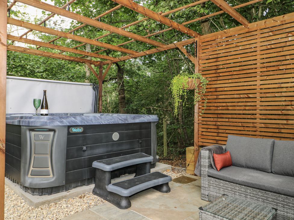 An outdoor space with a hot tub and seating area at Charltons Hollow Cabin in Haywards Heath