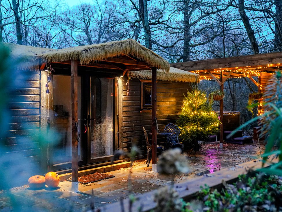 A cabin with pumpkins and a tree at Charltons Hollow Cabin in Bolney