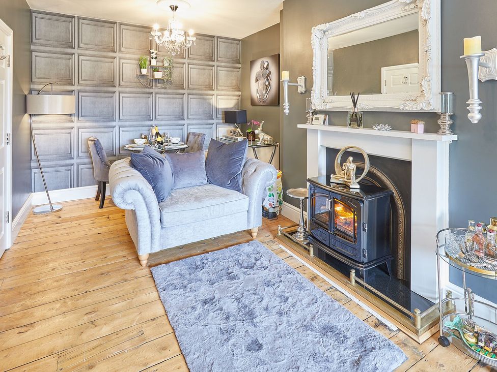 A living room with a sofa and fireplace at Apartment 2 in Whitby