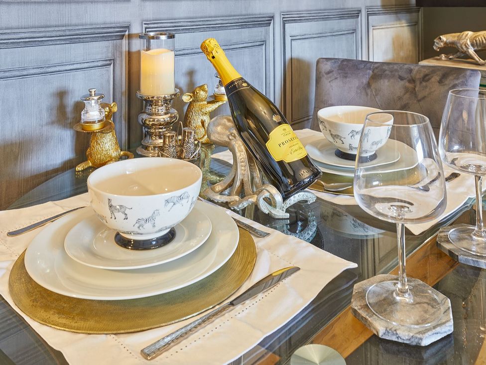 A dining table set with tableware and a wine bottle at Apartment 2 in Whitby