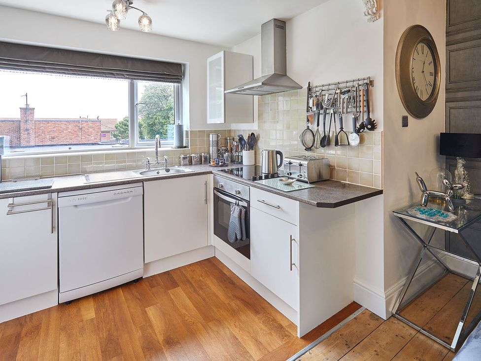 A kitchen with cabinets and utensils at Apartment 2 in Whitby