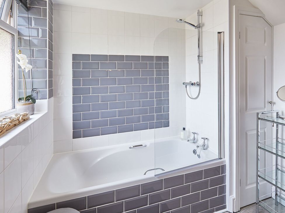 A bathroom with a bathtub and shower at Apartment 2 in Whitby