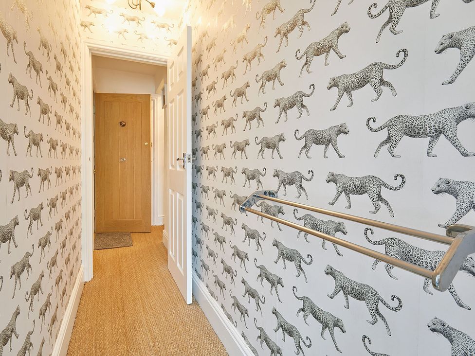 A hallway with patterned wallpaper and door at Apartment 2 in Whitby
