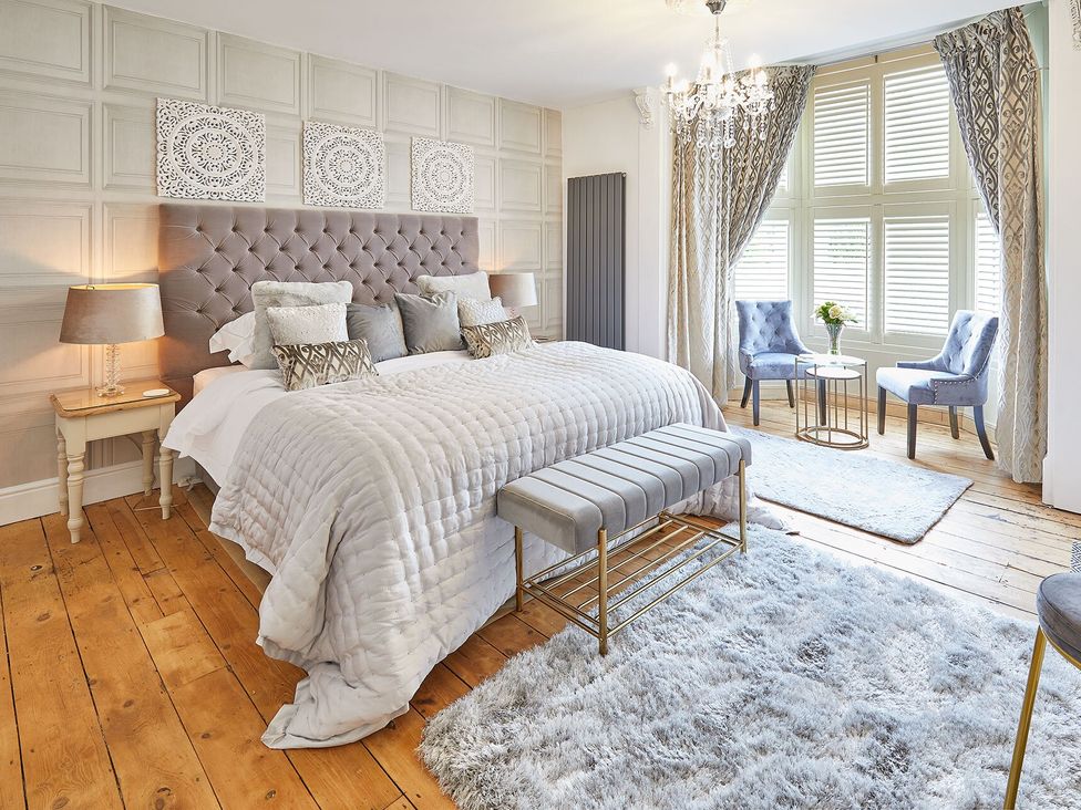 A bedroom with a bed and armchairs at Apartment 2 in Whitby