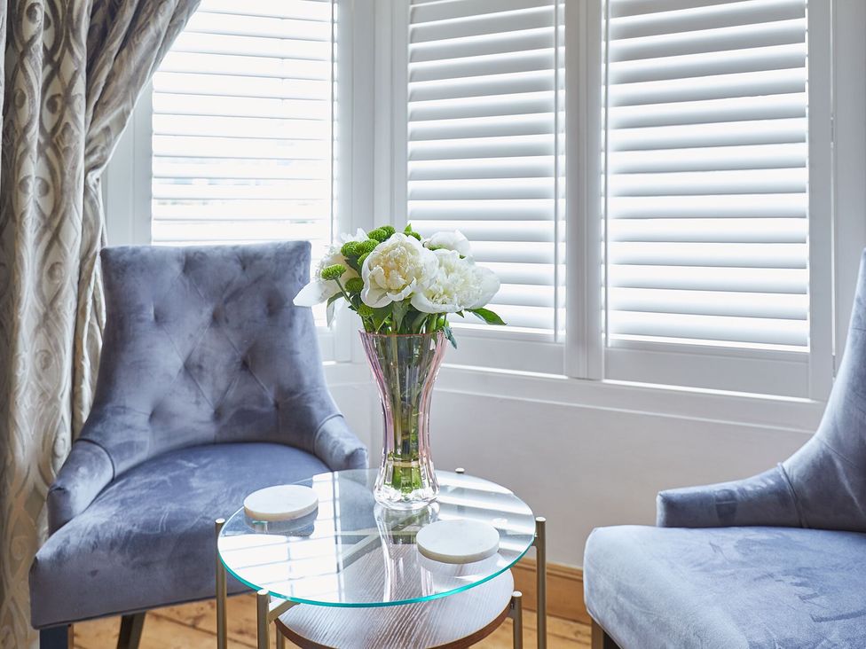 A sitting room with a vase of flowers on a table at Apartment 2 in Whitby