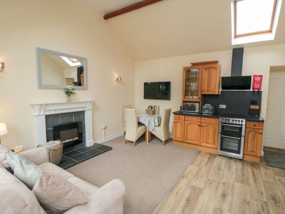 A living room with a kitchen area at Midsummer Cottage in Malton