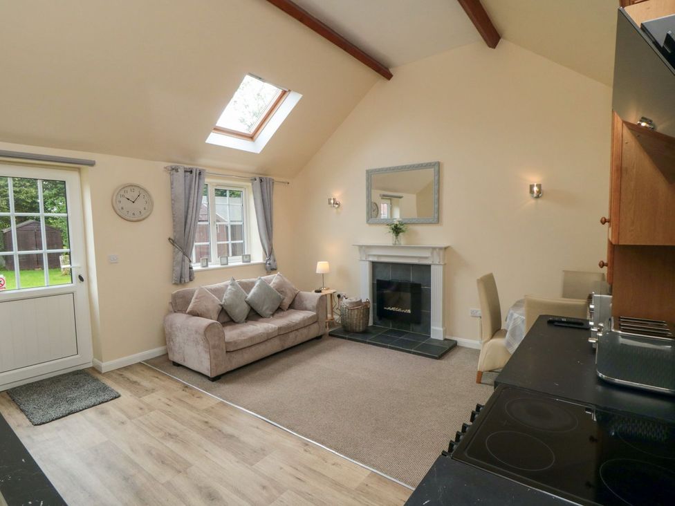 A living room with a sofa and fireplace at Midsummer Cottage in Malton