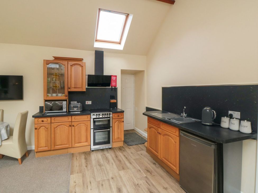 A kitchen with cabinetry and appliances at Midsummer Cottage in Malton