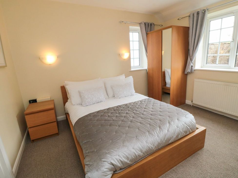 A bedroom with a bed and wardrobe at Midsummer Cottage in Malton