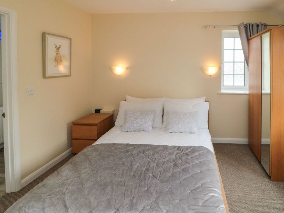 A bedroom with a bed and furniture at Midsummer Cottage in Malton
