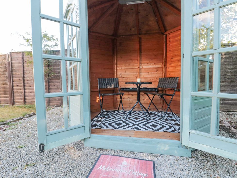 A garden room with table and chairs at Midsummer Cottage in Malton