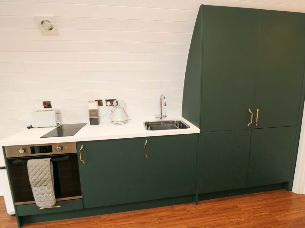 A kitchen with a sink and cooking appliances at Bumblebee Glamping Pod in Malton