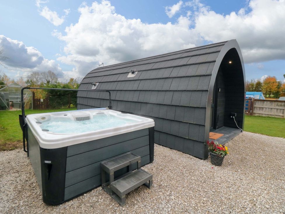 An outdoor area featuring a hot tub beside a building at Bumblebee Glamping Pod in Malton