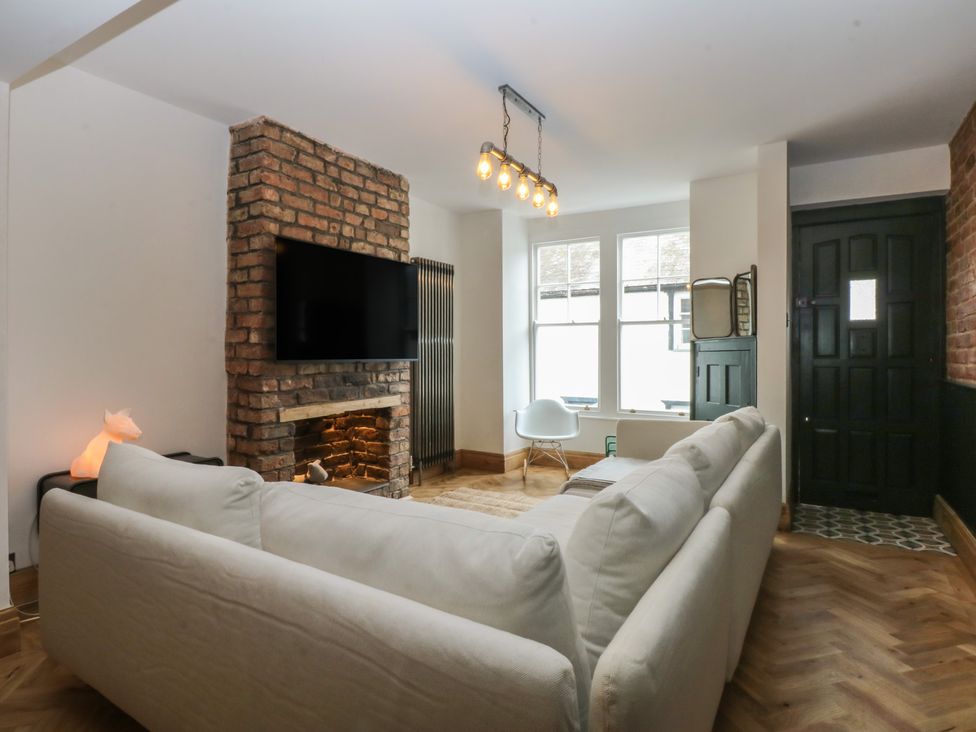A living room with a sofa and television at 5 Llewelyn Street Conwy