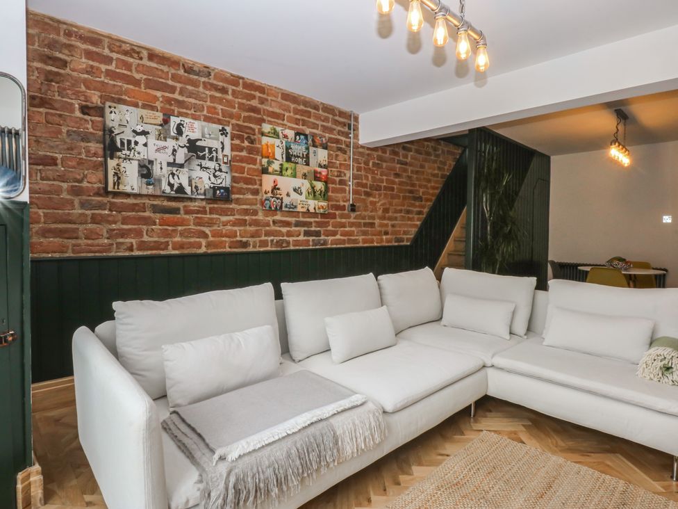 A living room with a sofa and brick wall at 5 Llewelyn Street Conwy
