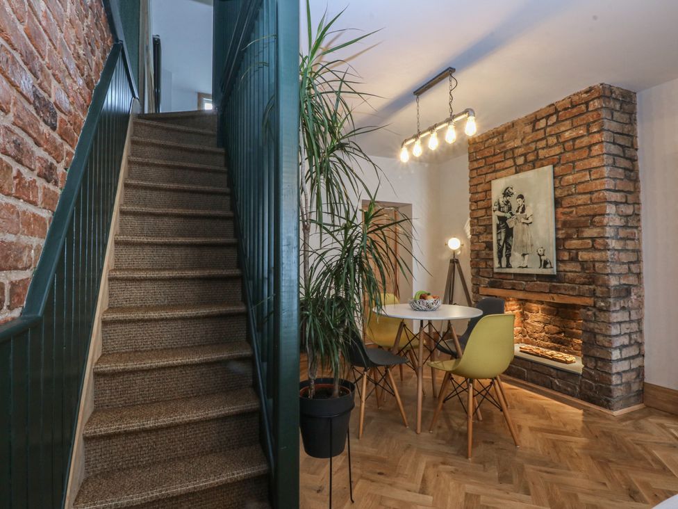 A dining room with a table and yellow chairs at 5 Llewelyn Street in Conwy