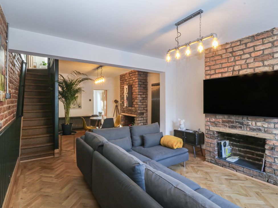 A living room with a sofa and television at Ty Gelert in Conwy