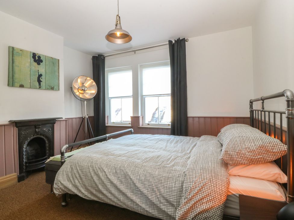 A bedroom with a bed and window at Ty Gelert in Conwy