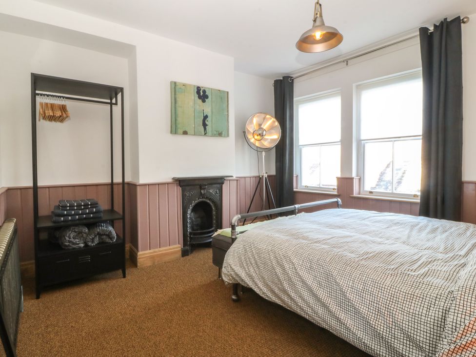 A bedroom with a bed and wardrobe at Ty Gelert in Conwy