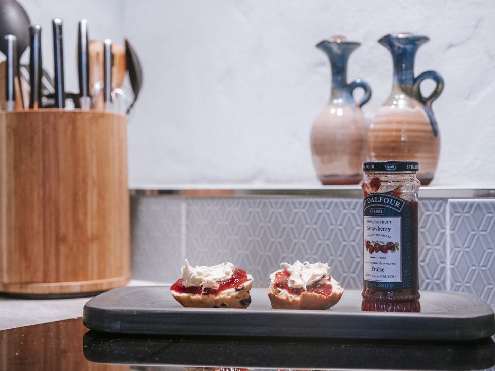 A kitchen with scones and strawberry jam on a tray at Tamarisk Cottage St. Agnes