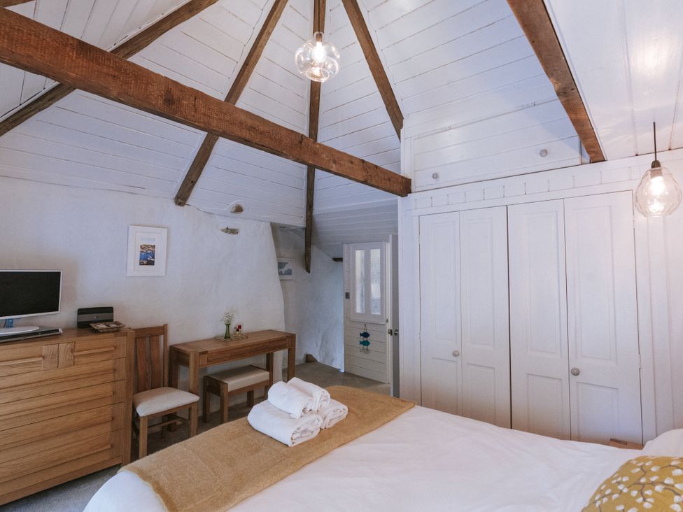 A bedroom with a bed and dresser at Tamarisk Cottage in St. Agnes