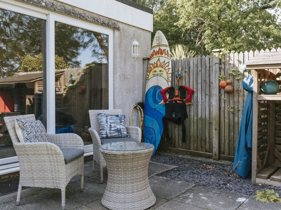 An outdoor patio with chairs and a table at Tamarisk Cottage in St. Agnes
