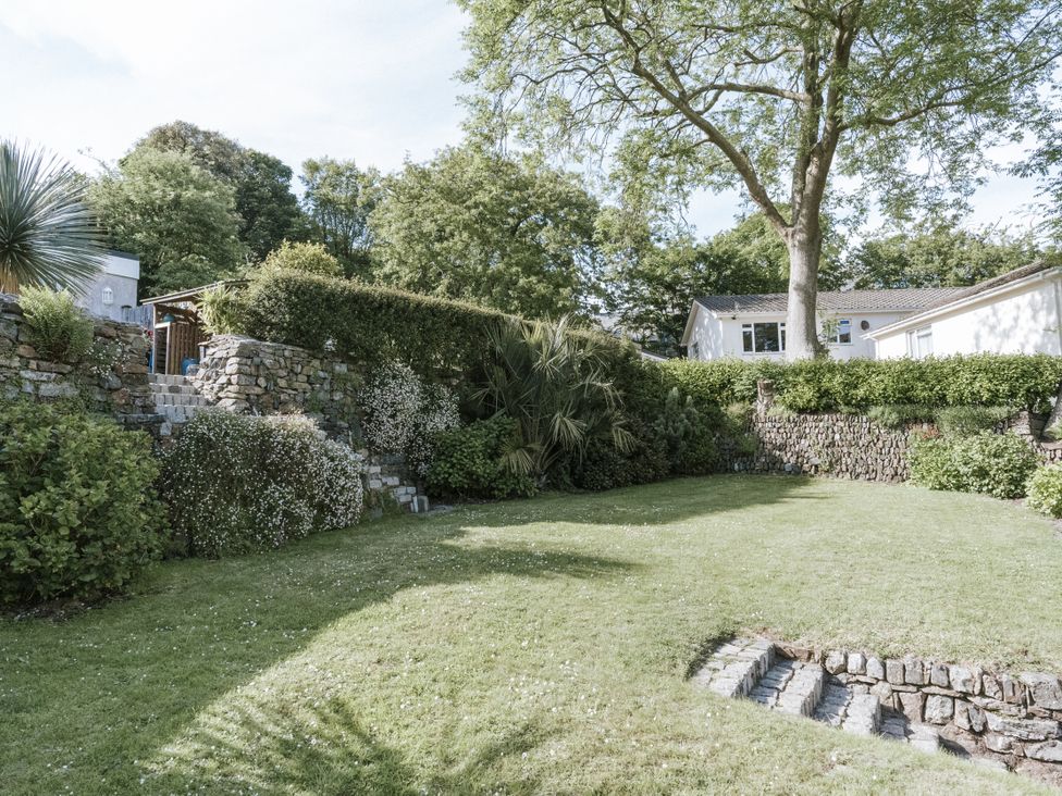 A garden with grass and stone features at Tamarisk Cottage in St. Agnes