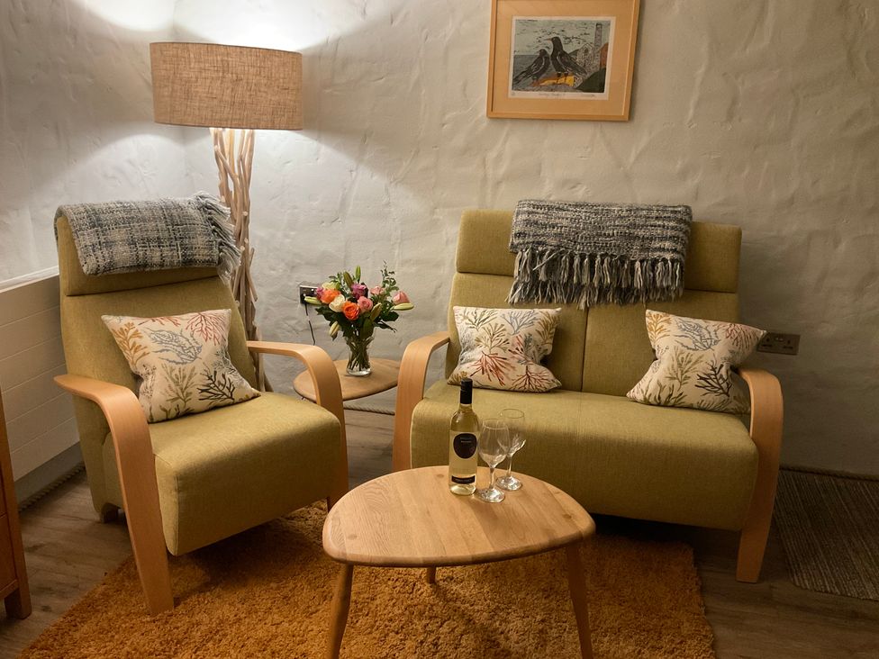 A living room with chairs and a table at Tamarisk Cottage in St Agnes