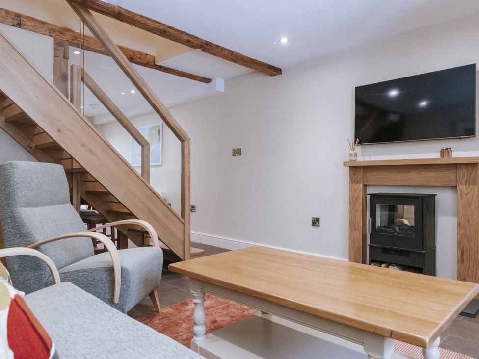 A living room with a staircase and fireplace at Bluck's cottage St. Agnes