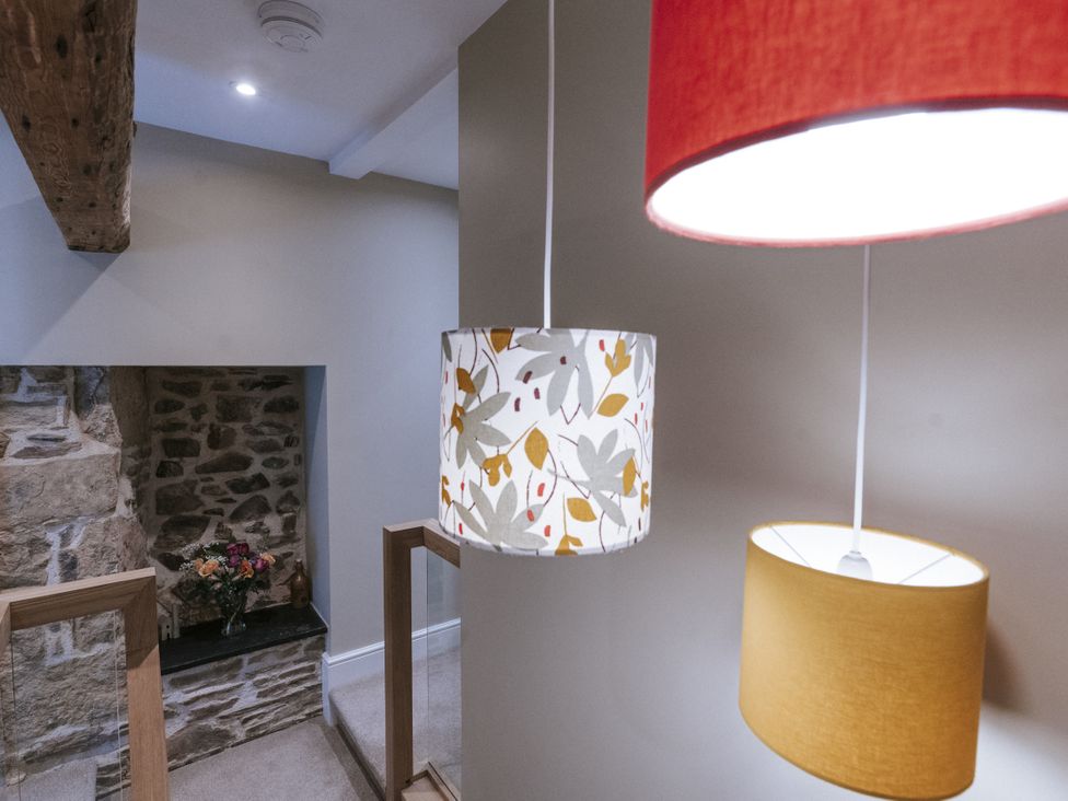 A staircase with hanging lights and a flower arrangement at Bluck's cottage St. Agnes