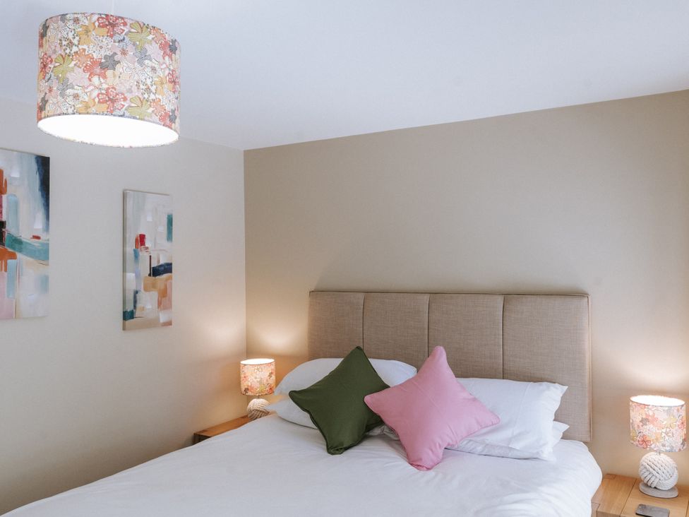 A bedroom with a bed and artwork on the wall at Bluck's cottage in St. Agnes