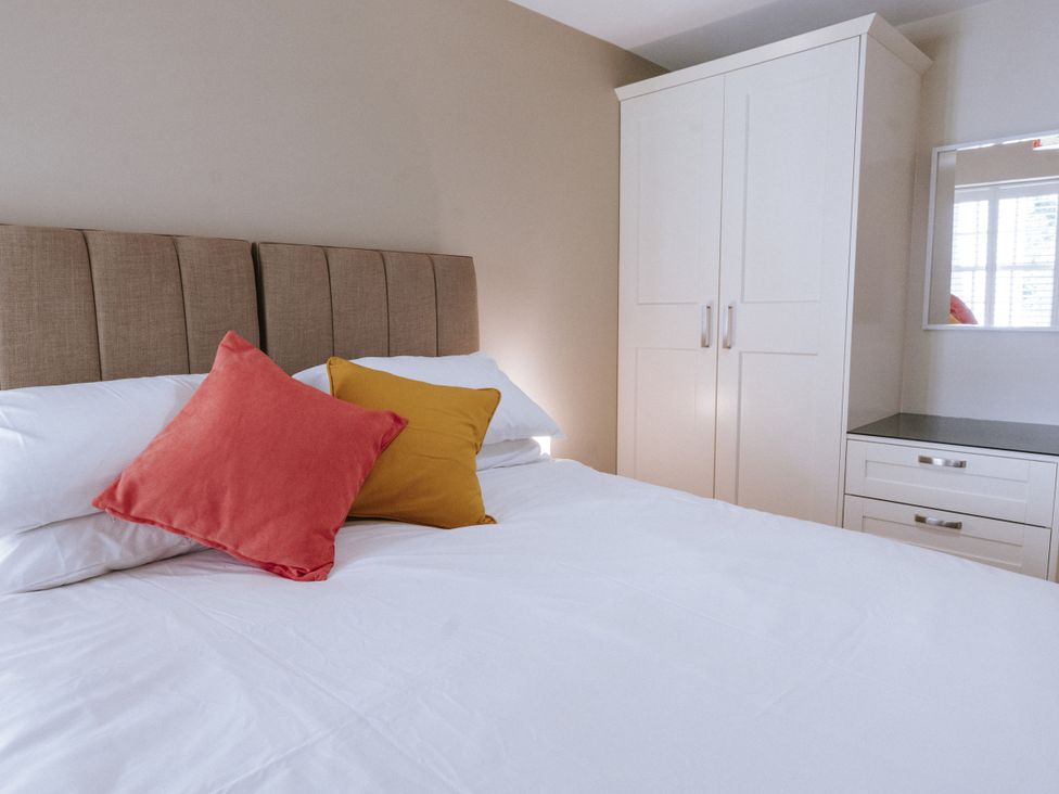 A bedroom with a bed and wardrobe at Bluck's cottage in St. Agnes