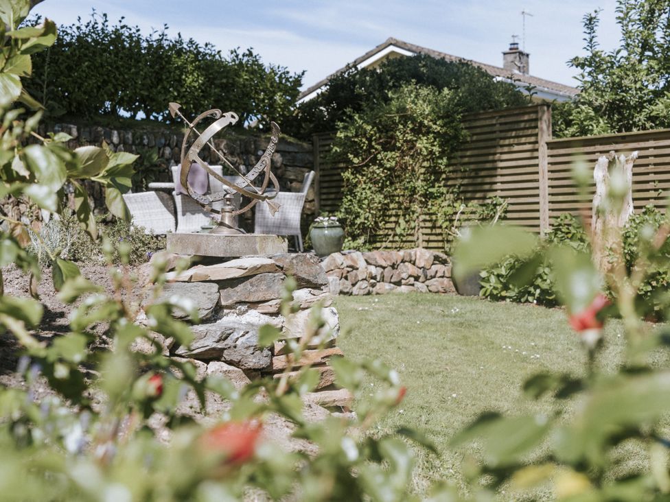 A garden with a sundial and chairs at Bluck's cottage St. Agnes