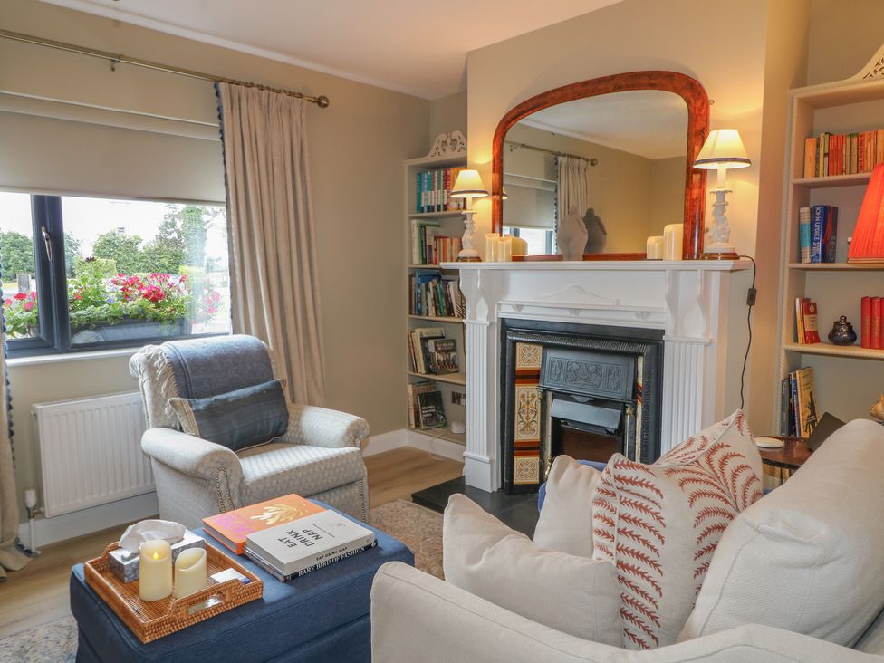 A living room with an armchair and a fireplace at Clarmes House in Limavady