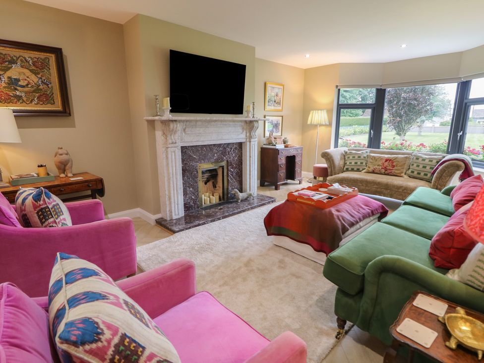 A living room with a fireplace and sofas at Clarmes House in Limavady