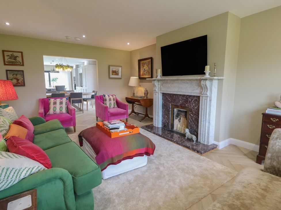 A living room with a fireplace and television at Clarmes House in Limavady