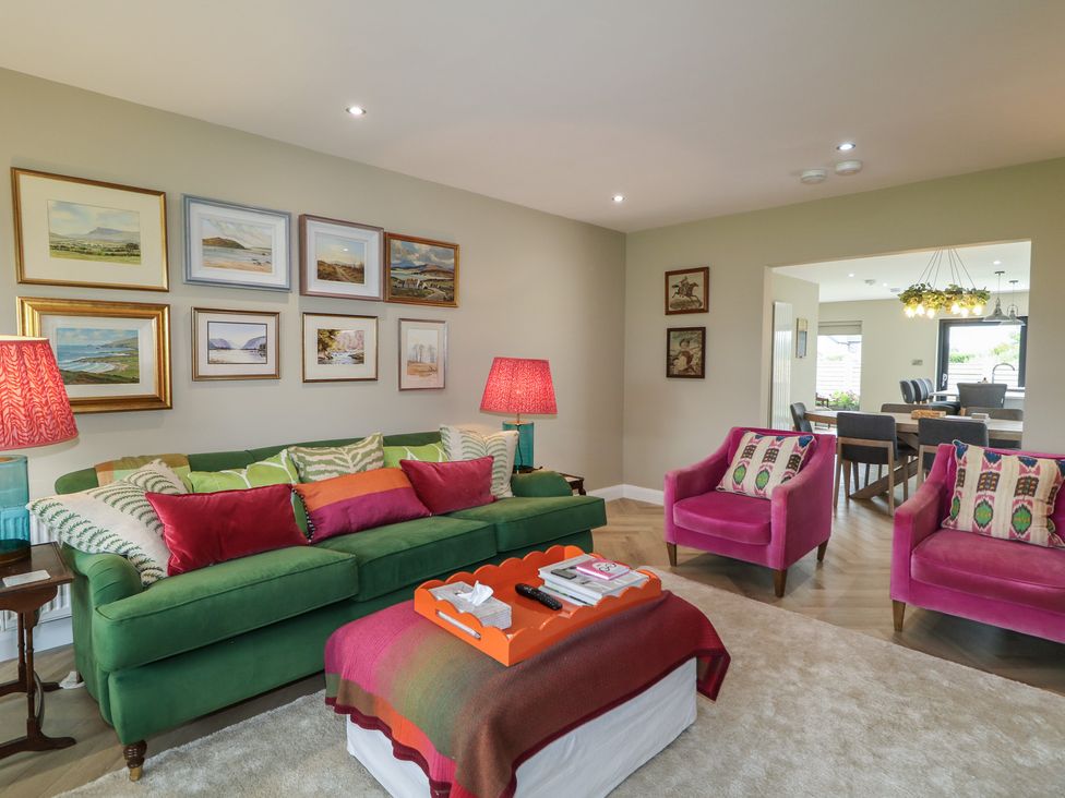 A living room with a green sofa and pink chairs at Clarmes House in Limavady