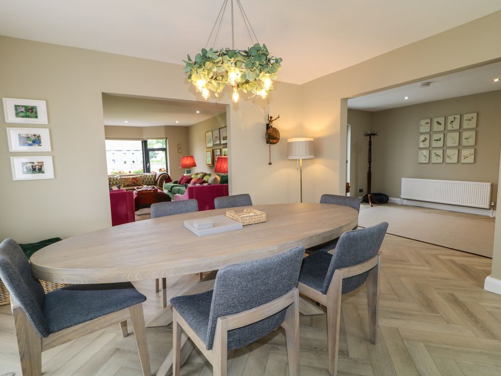 A dining room with a round table and chairs at Clarmes House Limavady