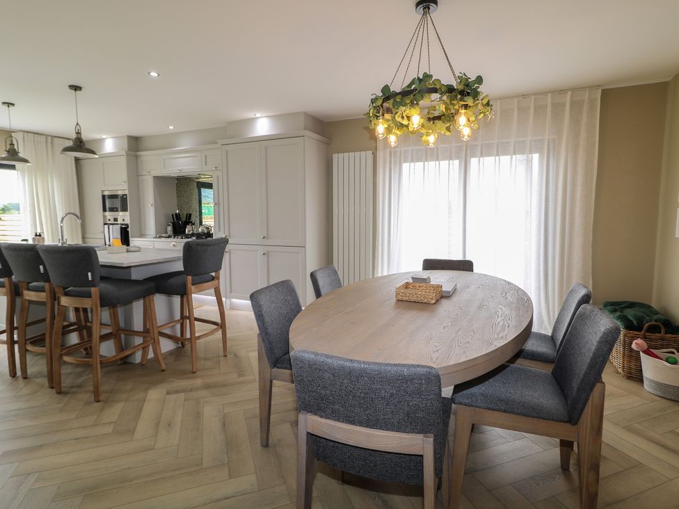 A kitchen with an island and dining table at Clarmes House in Limavady