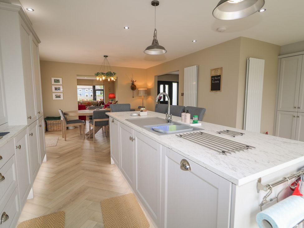 A kitchen with a central island and cabinets at Clarmes House Limavady