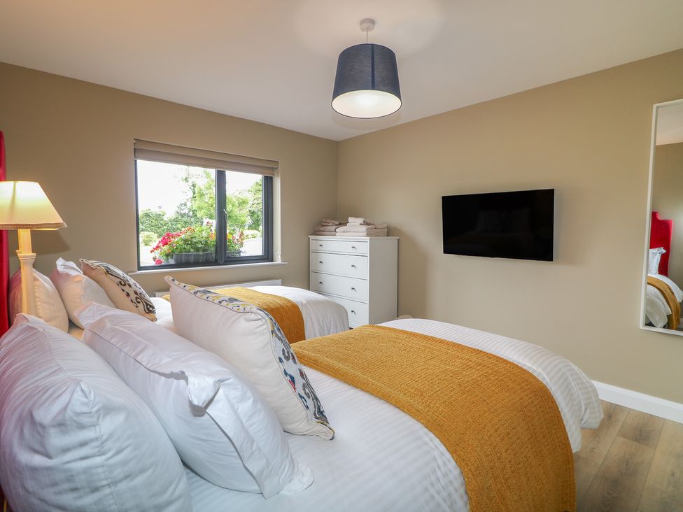 A bedroom with two beds and a window at Clarmes House in Limavady
