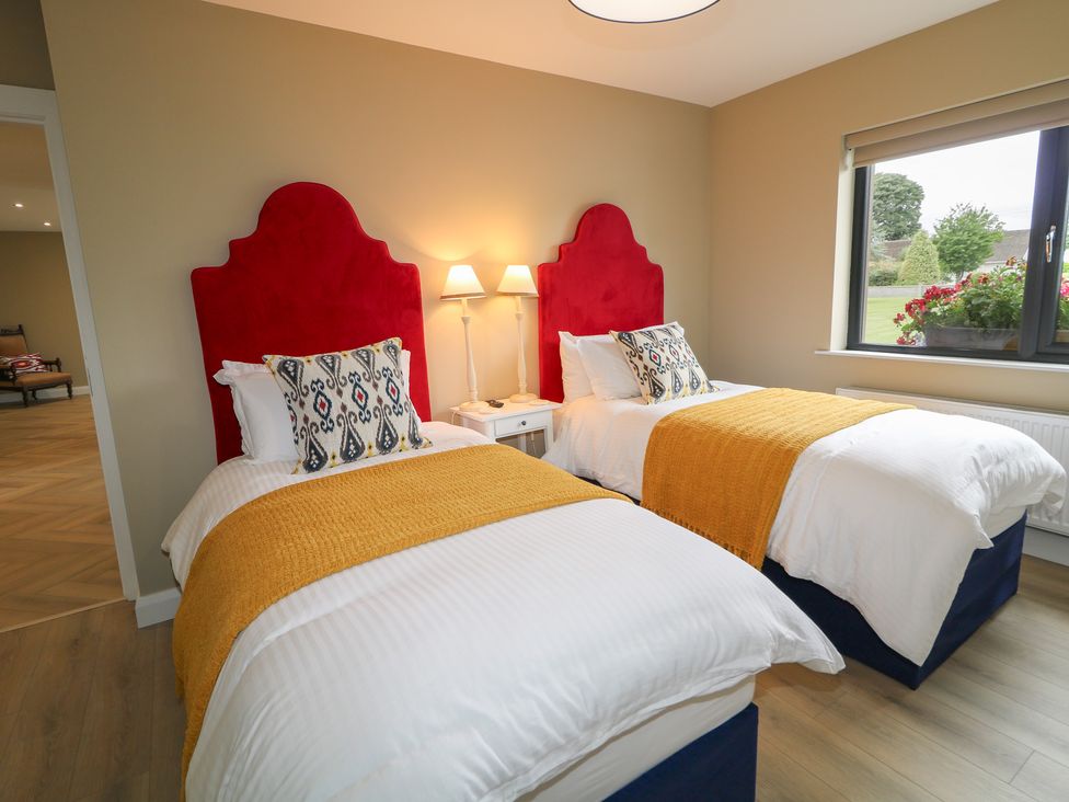A bedroom with twin beds and a window at Clarmes House Limavady