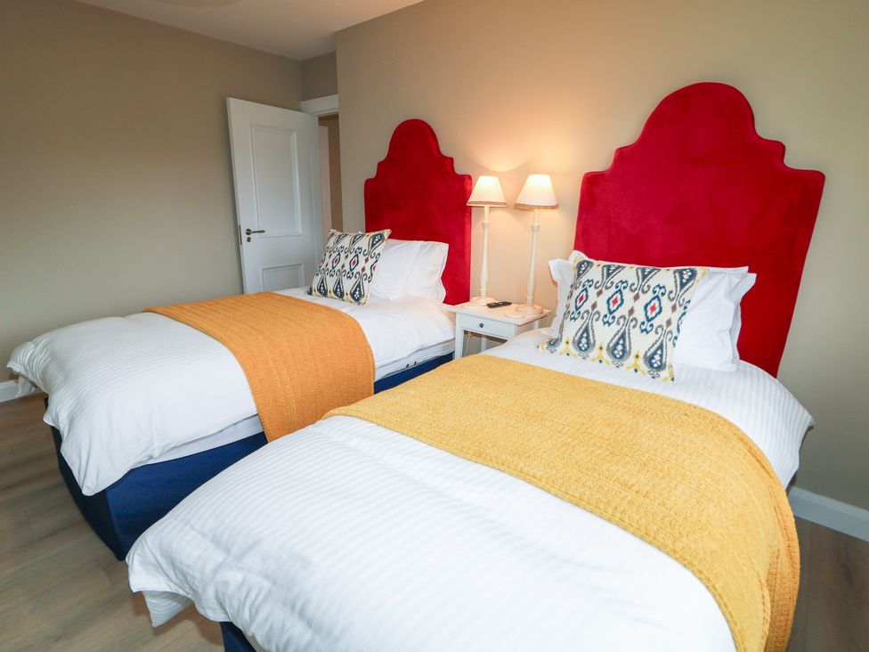 A bedroom with two beds and a nightstand at Clarmes House in Limavady