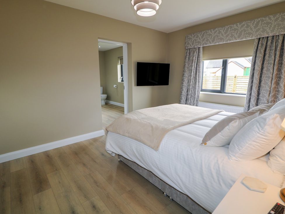 A bedroom with a bed and a wall-mounted TV at Clarmes House in Limavady
