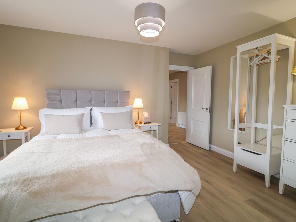 A bedroom with a bed, nightstand, lamp, wardrobe at Clarmes House Limavady
