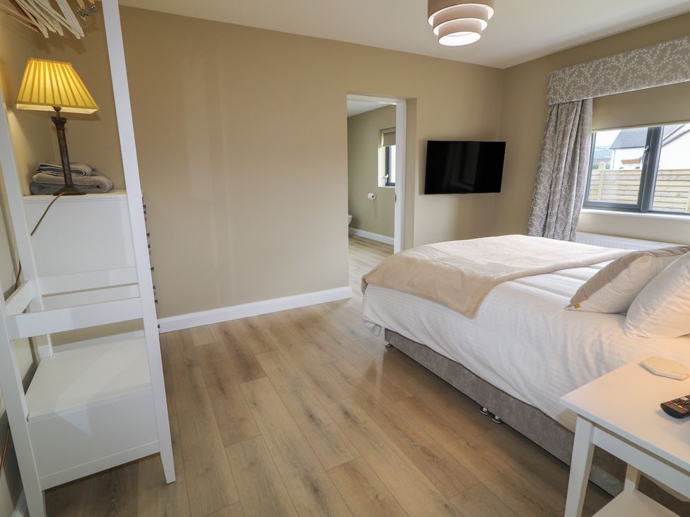 A bedroom with a bed and a television at Clarmes House in Limavady