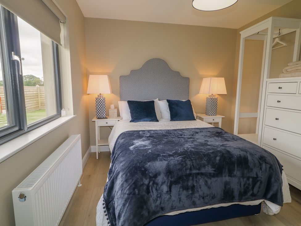 A bedroom with a bed and two lamps at Clarmes House in Limavady